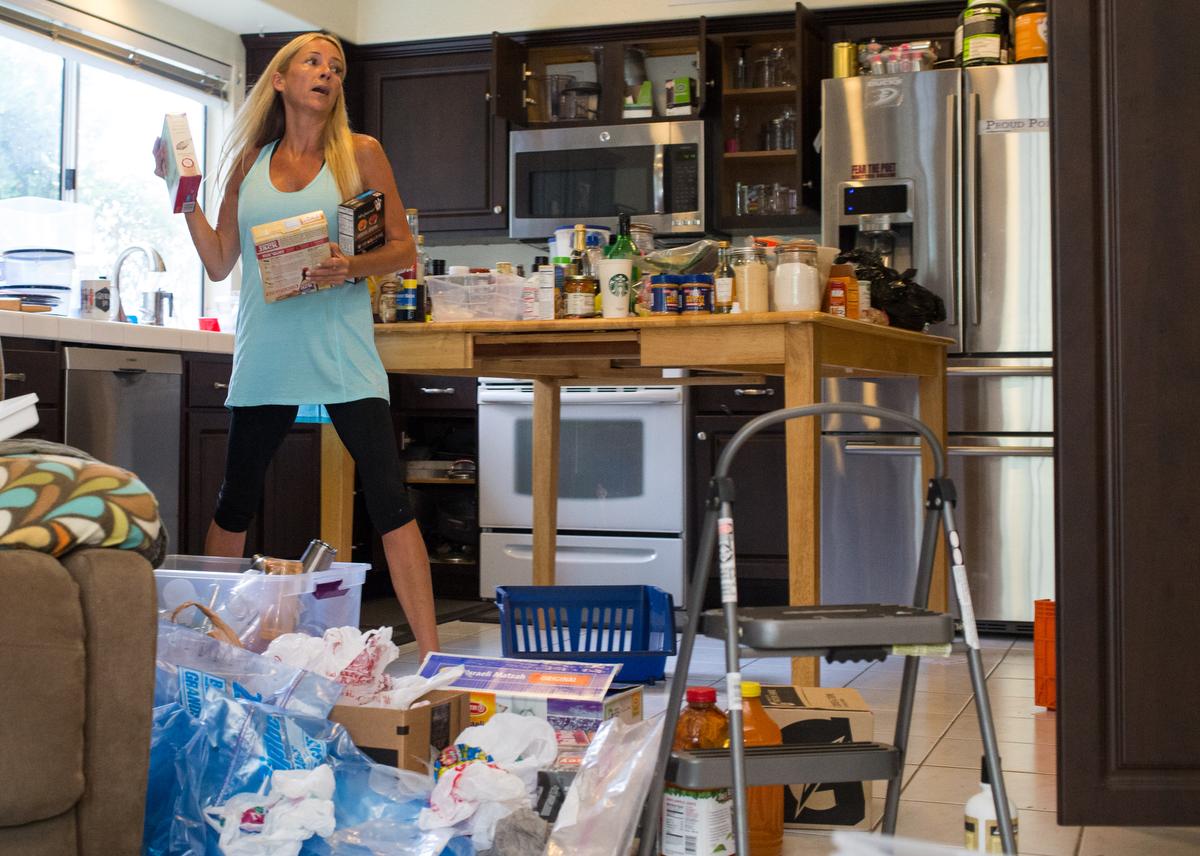 Professional organizer Kirsten Ranger of Organized & Orderly navigates around the contents of a kitchen pantry while decluttering at a private residence in Trabuco Canyon on Tuesday. ////ADDITIONAL INFORMATION: lansner.declutter - 7/7/15 - JOSH BARBER, - ORANGE COUNTY REGISTER - at on Tuesday, July 7, 2015 in Trabuco Canyon, Calif. Columnist Jon Lansner will have a room in his home "decluttered" by decluttering expert Kirsten Ranger of Organized & Orderly of Organized & Orderly